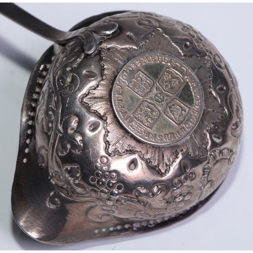 118 - A George III silver coloured metal toddy ladle, the bowl chased with fruiting vine and set with a gi... 