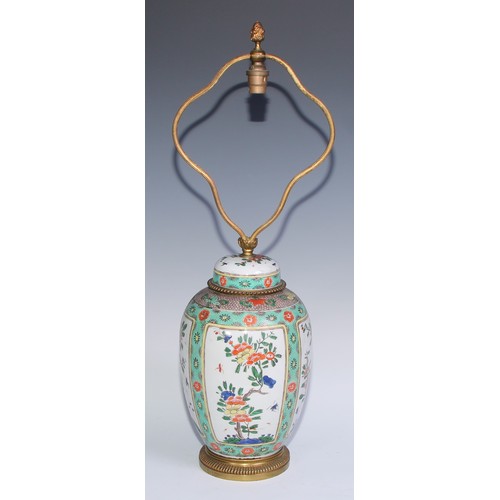 744 - A Chinese famille verte ovoid vase and cover, painted with flowering branches within rectangular res... 