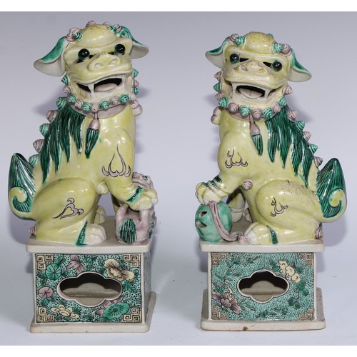 782 - A pair of Chinese porcelain models of temple dogs, decorated in tones of yellow, green and manganese... 