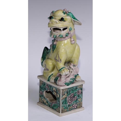 782 - A pair of Chinese porcelain models of temple dogs, decorated in tones of yellow, green and manganese... 