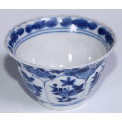 784 - A pair of Chinese wine cups or tea bowls and saucers, painted in tones of underglaze blue with flowe... 