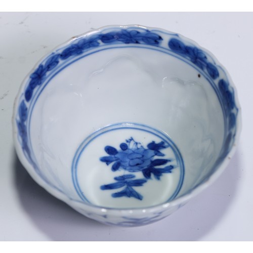 784 - A pair of Chinese wine cups or tea bowls and saucers, painted in tones of underglaze blue with flowe... 