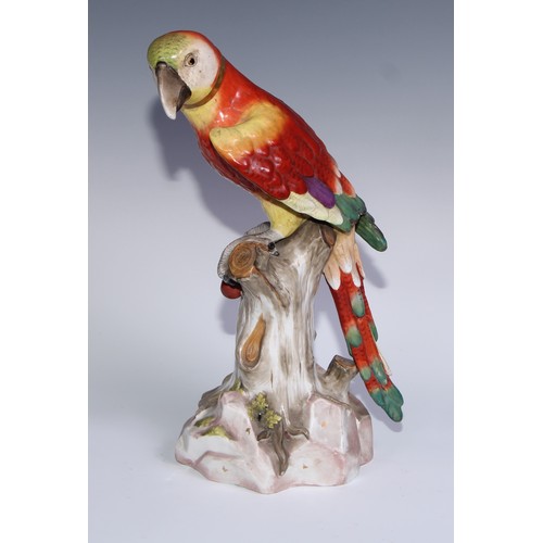 530 - A pair of German porcelain models of parrots, in the manner of Meissen, brightly painted and perched... 