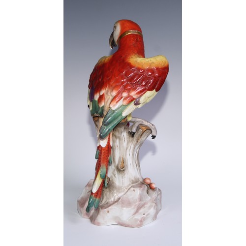 530 - A pair of German porcelain models of parrots, in the manner of Meissen, brightly painted and perched... 