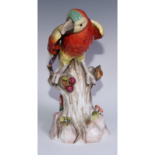 530 - A pair of German porcelain models of parrots, in the manner of Meissen, brightly painted and perched... 