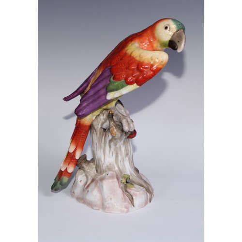 530 - A pair of German porcelain models of parrots, in the manner of Meissen, brightly painted and perched... 