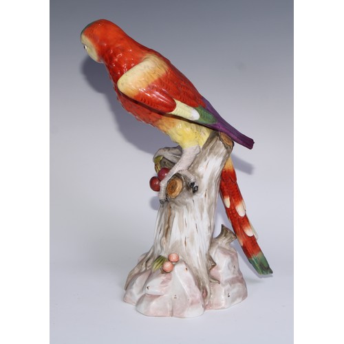 530 - A pair of German porcelain models of parrots, in the manner of Meissen, brightly painted and perched... 