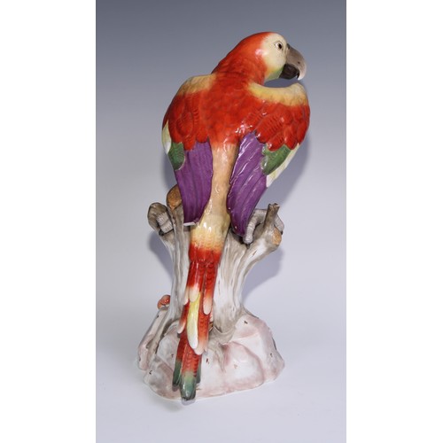 530 - A pair of German porcelain models of parrots, in the manner of Meissen, brightly painted and perched... 