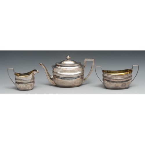 134 - A George III silver three piece boat shaped tea service, comprising teapot, milk jug and sugar basin... 