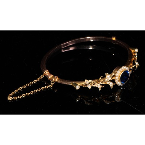 351 - A late 19th/early 20th century 15ct gold hinged bangle bracelet, set with a central sapphire accente... 