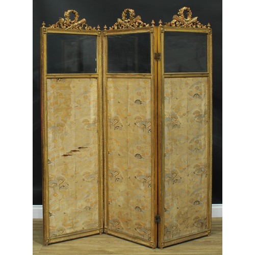 1353 - A Louis XVI Revival giltwood and gesso three-fold screen, each bevelled quarter-glazed panel crested... 