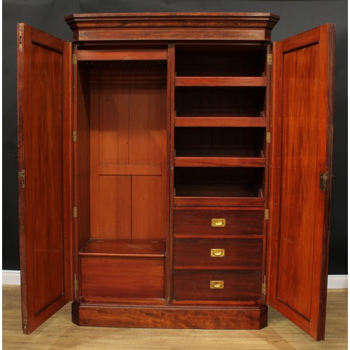 943 - A 19th century mahogany wardrobe, outswept cornice above a pair of raised and fielded panel doors en... 