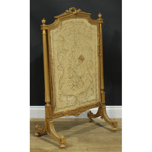 1354 - A Louis XVI Revival giltwood fire screen, arched cresting carved with a quiver of arrows crossed wit... 