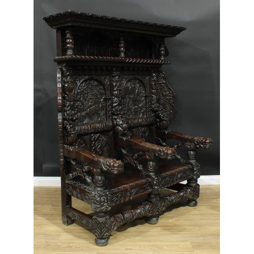 1280 - A large 17th century style oak settle, carved throughout with native folk scenes, grotesque masks an... 