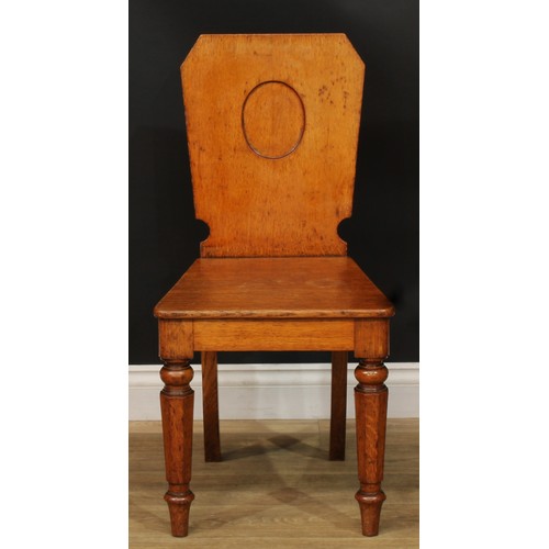 1409 - A pair of Victorian oak hall chairs, each with a shaped rectangular back with vacant oval crest rese... 