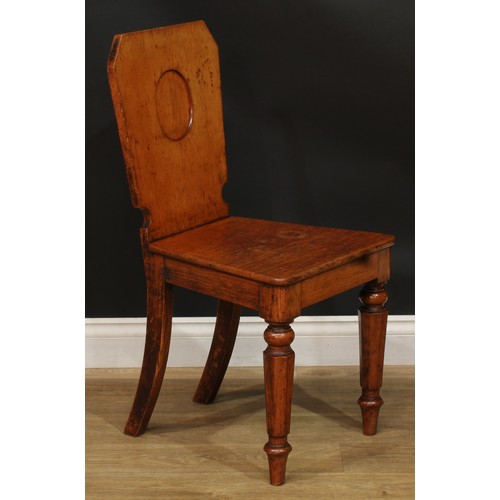 1409 - A pair of Victorian oak hall chairs, each with a shaped rectangular back with vacant oval crest rese... 