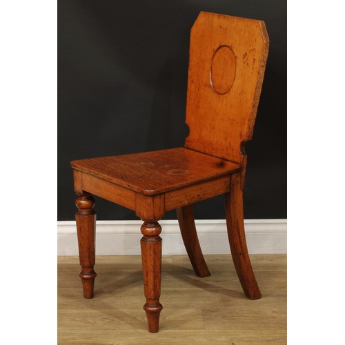 1409 - A pair of Victorian oak hall chairs, each with a shaped rectangular back with vacant oval crest rese... 