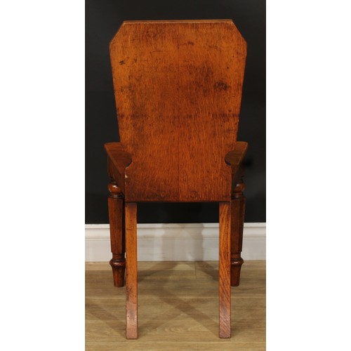 1409 - A pair of Victorian oak hall chairs, each with a shaped rectangular back with vacant oval crest rese... 