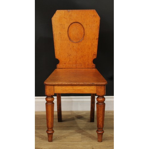 1409 - A pair of Victorian oak hall chairs, each with a shaped rectangular back with vacant oval crest rese... 