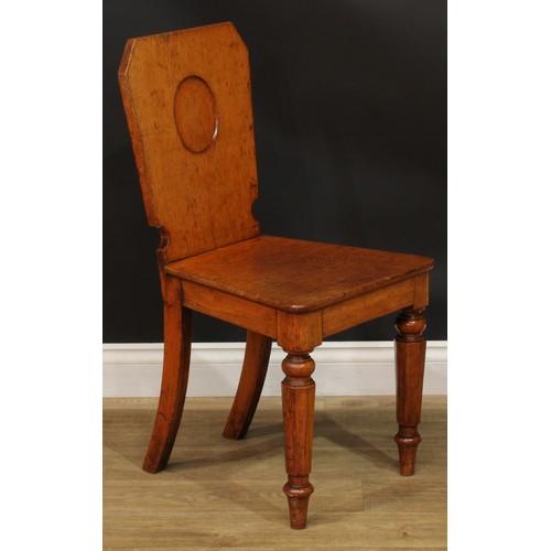 1409 - A pair of Victorian oak hall chairs, each with a shaped rectangular back with vacant oval crest rese... 