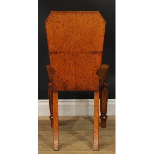 1409 - A pair of Victorian oak hall chairs, each with a shaped rectangular back with vacant oval crest rese... 