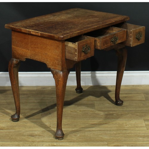 1100 - A George II walnut lowboy, crossbanded quarter-veneered top above three frieze drawers, shaped apron... 