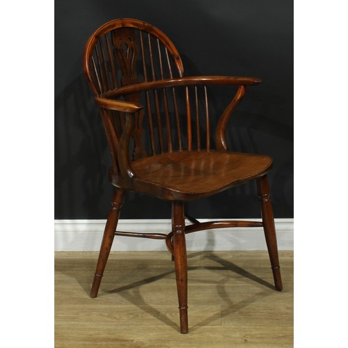 1010 - A 19th century yew and elm Windsor elbow chair, low hoop back, shaped and pierced splat, saddle seat... 