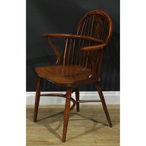 1010 - A 19th century yew and elm Windsor elbow chair, low hoop back, shaped and pierced splat, saddle seat... 