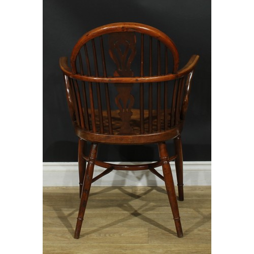 1010 - A 19th century yew and elm Windsor elbow chair, low hoop back, shaped and pierced splat, saddle seat... 