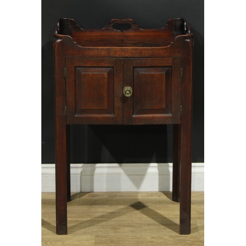 1233 - A George III mahogany tray top bedroom night cupboard, shaped and pierced gallery above a pair of ra... 