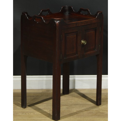 1233 - A George III mahogany tray top bedroom night cupboard, shaped and pierced gallery above a pair of ra... 