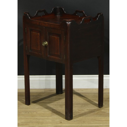 1233 - A George III mahogany tray top bedroom night cupboard, shaped and pierced gallery above a pair of ra... 