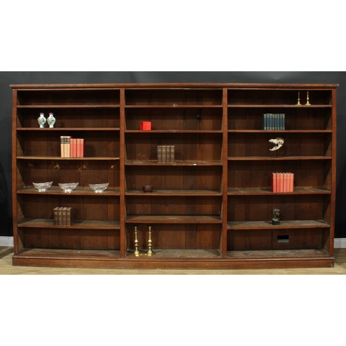 1285 - A large early 20th century oak library bookcase, formed of three sections, adjustable shelves, plint... 