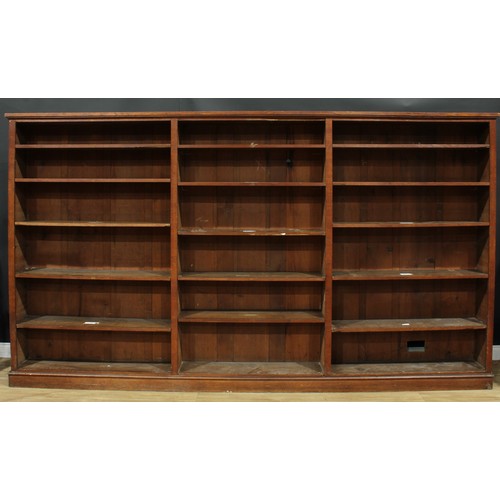 1285 - A large early 20th century oak library bookcase, formed of three sections, adjustable shelves, plint... 