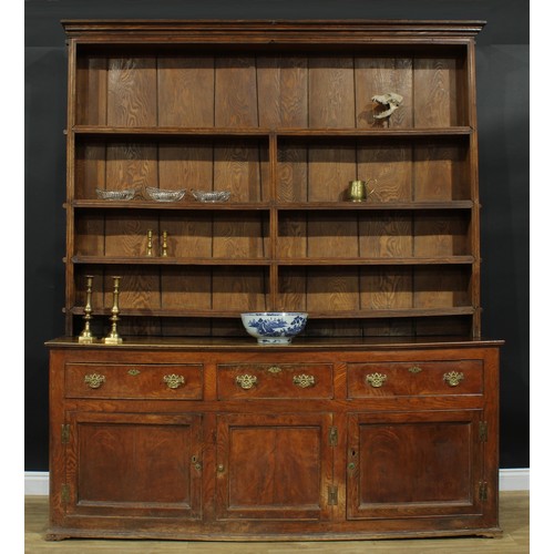 1286 - A large George III ash and elm country house dresser, outswept cornice above four plate rack shelves... 