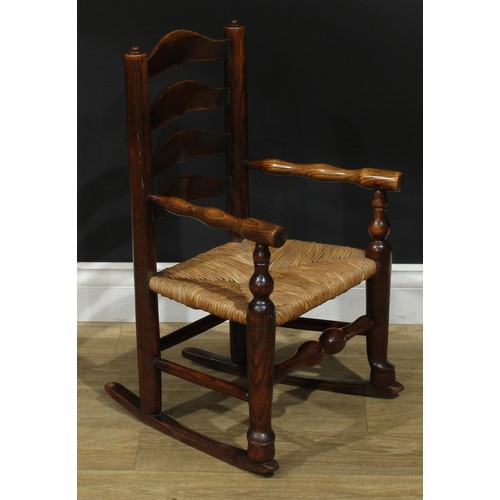 909 - A 19th century Lancashire ash miniature ladderback rocking chair, turned arms, rush seat, 66cm high,... 