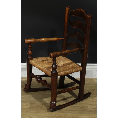 909 - A 19th century Lancashire ash miniature ladderback rocking chair, turned arms, rush seat, 66cm high,... 