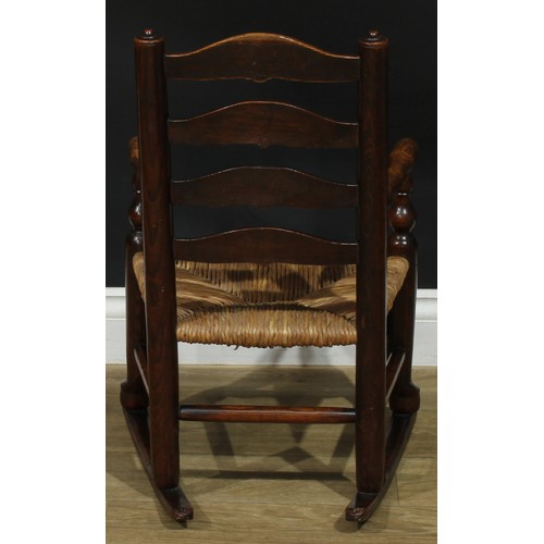 909 - A 19th century Lancashire ash miniature ladderback rocking chair, turned arms, rush seat, 66cm high,... 