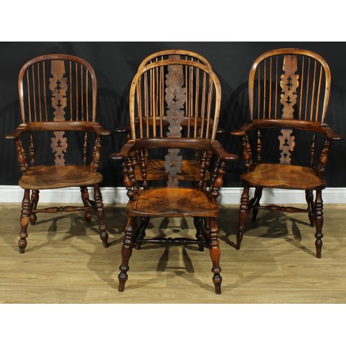 1369 - A near set of four 19th century Yorkshire yew and elm Windsor elbow chairs, each with a hoop back, s... 