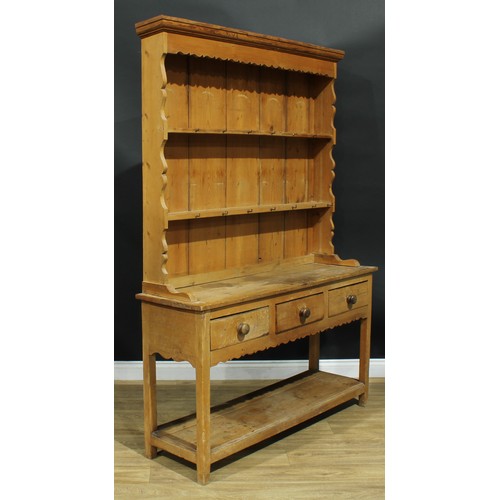 991 - A 19th century pine potboard dresser, moulded cornice above two plate racks, the projecting base wit... 