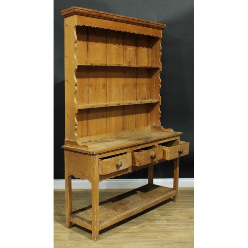 991 - A 19th century pine potboard dresser, moulded cornice above two plate racks, the projecting base wit... 