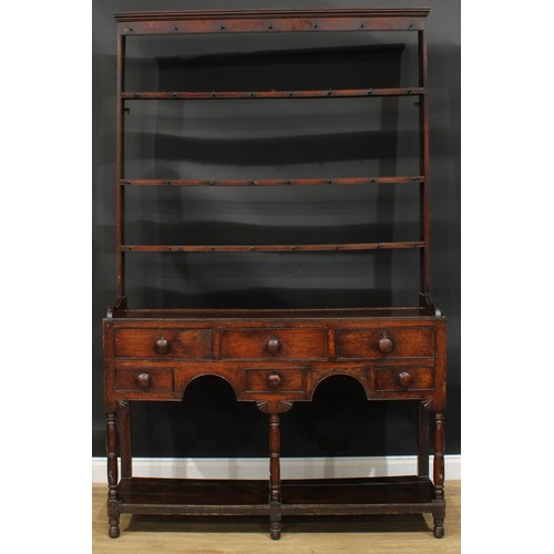 1167 - A George III oak potboard dresser, moulded cornice above three plate racks, the projecting base with... 