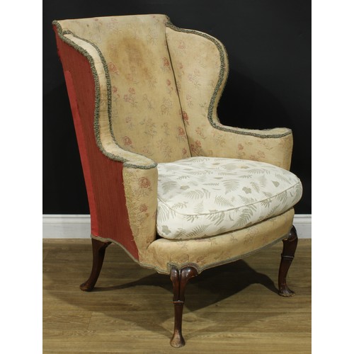 1099 - A George II Revival wingback armchair, stuffed-over upholstery, squab cushion, cabriole forelegs, pa... 