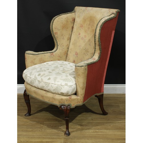 1099 - A George II Revival wingback armchair, stuffed-over upholstery, squab cushion, cabriole forelegs, pa... 