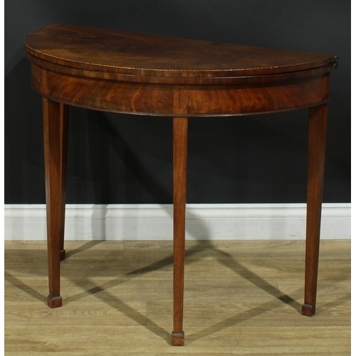 1115 - A George III mahogany demilune tea table, hinged top, tapered square legs, one rear concealing a sec... 