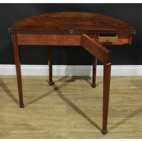 1115 - A George III mahogany demilune tea table, hinged top, tapered square legs, one rear concealing a sec... 