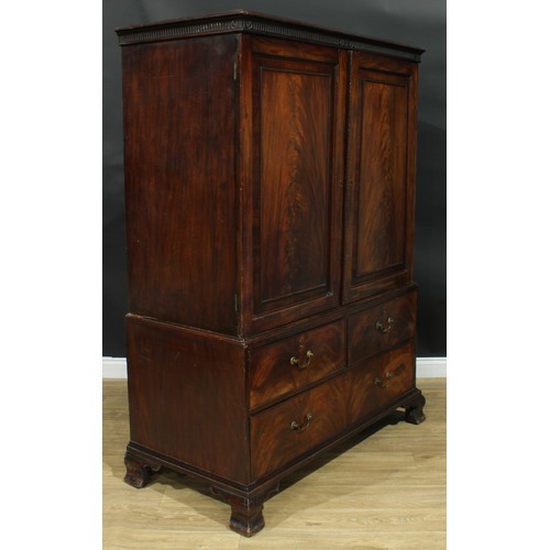 1222 - A George III mahogany linen press, nulled cornice above a pair of flame veneered panel doors enclosi... 