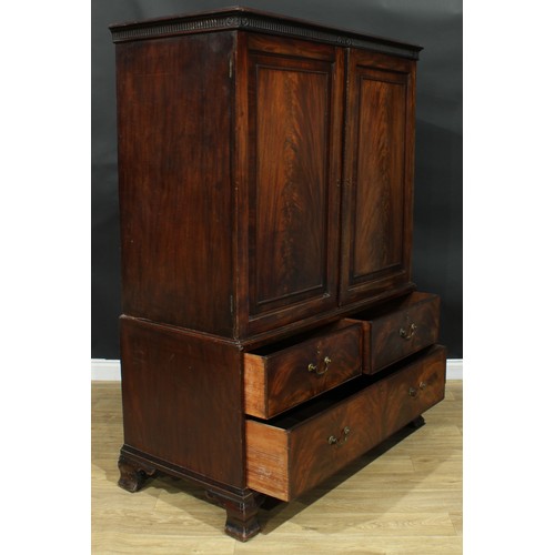 1222 - A George III mahogany linen press, nulled cornice above a pair of flame veneered panel doors enclosi... 