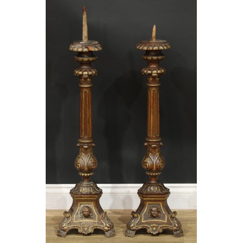 1403 - A pair of North European parcel-gilt oak altar pricket candlesticks, fluted pillars, acanthus socles... 