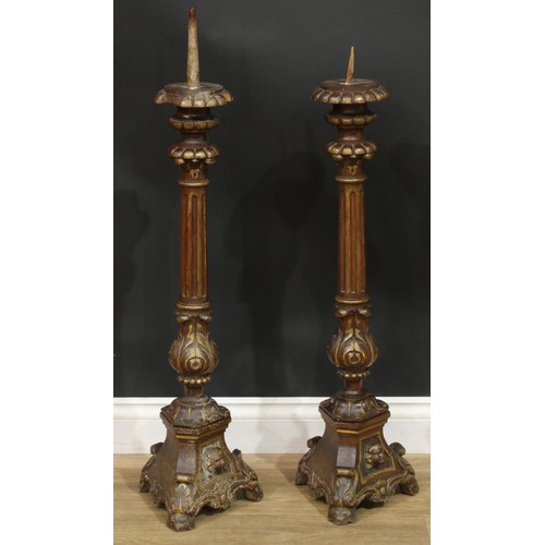 1403 - A pair of North European parcel-gilt oak altar pricket candlesticks, fluted pillars, acanthus socles... 